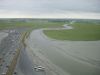 Vue de l'exterieur du mont, le parking/digue en contrebas et le Couesnon, limite entre la Bretagne et la Normandie