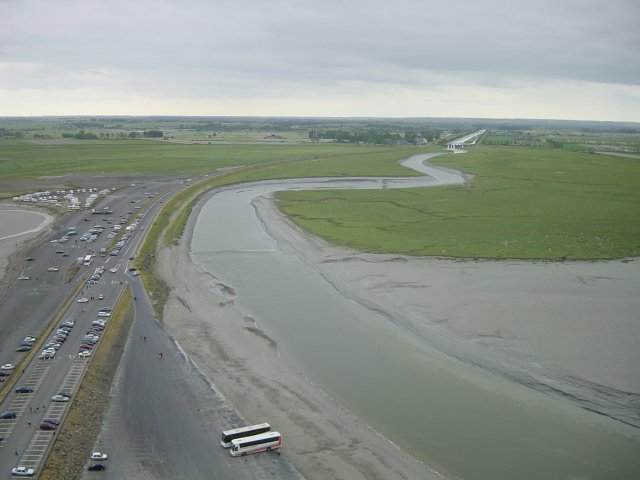 Vue de l'exterieur du mont, le parking/digue en contrebas et le Couesnon, limite entre la Bretagne et la Normandie